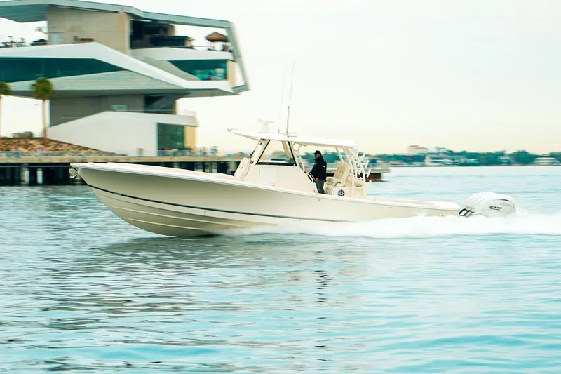 Slide: The Image of 2024 Regulator 41 boat cruising near modern waterfront building. - 57