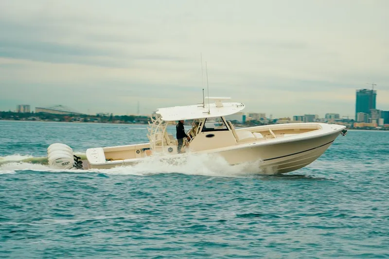 Slide: The Image of 2024 Regulator 41 boat cruising on open water with city skyline in background. - 61