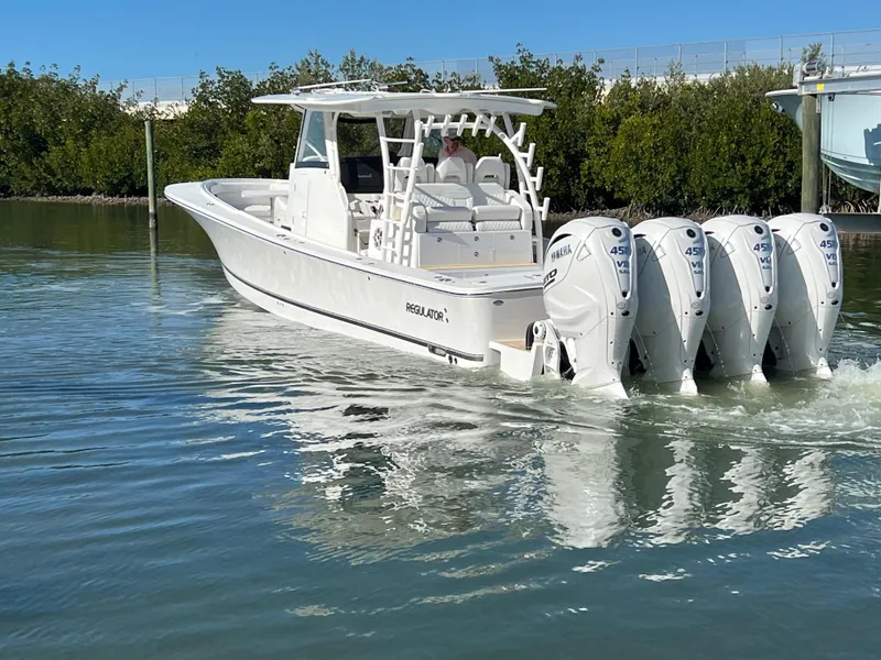 Slide: The Image of 2024 Regulator 41 boat with four powerful engines cruising on calm water. - 7