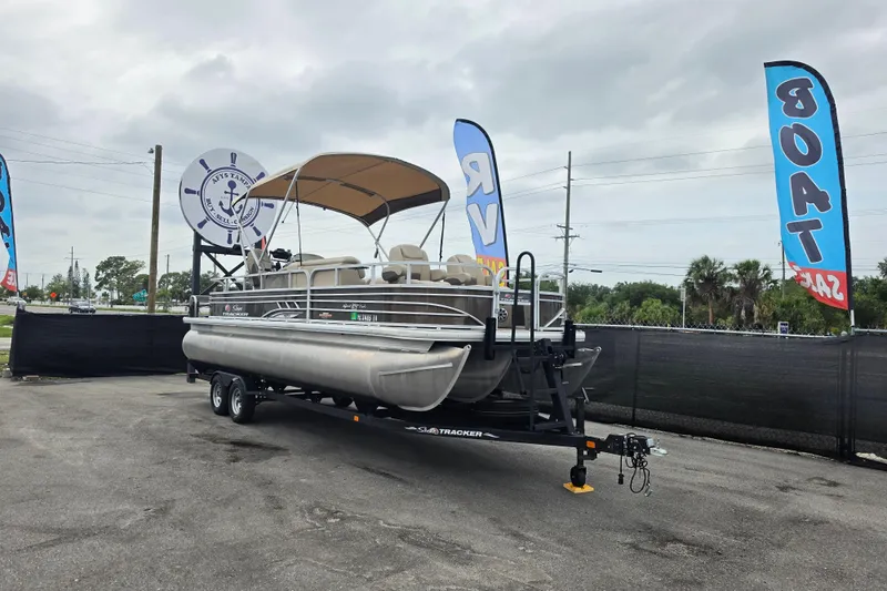 The Image of 2023 Sun Tracker Sportfish 24 XP3 pontoon boat on trailer at dealership. - 0