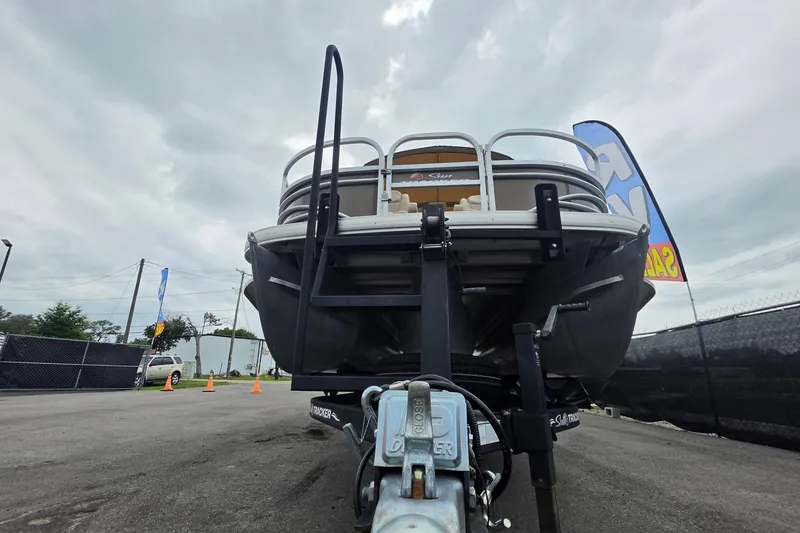 Slide: The Image of 2023 Sun Tracker Bass Buggy 18 DLX pontoon boat on trailer, overcast sky background. - 11