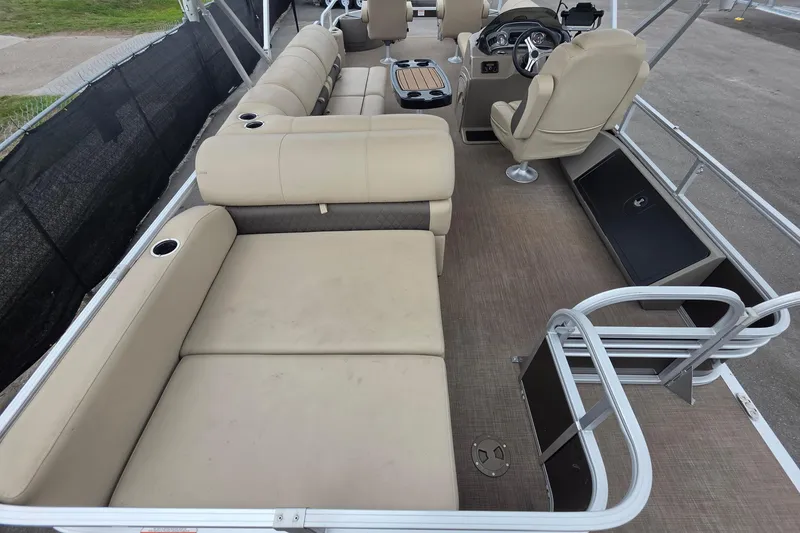 Slide: The Image of 2023 Sun Tracker Bass Buggy 18 DLX pontoon boat interior with beige seating and steering console. - 17