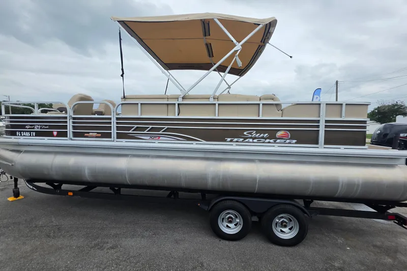 Slide: The Image of 2023 Sun Tracker Bass Buggy 18 DLX pontoon boat with canopy on trailer. - 2