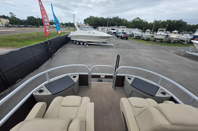 Slide: The Image of 2023 Sun Tracker Bass Buggy 18 DLX pontoon boat at dealership, surrounded by other boats. - 33