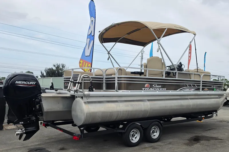 Slide: The Image of 2023 Sun Tracker Sportfish 24 XP3 pontoon boat with Mercury outboard motor on trailer. - 2