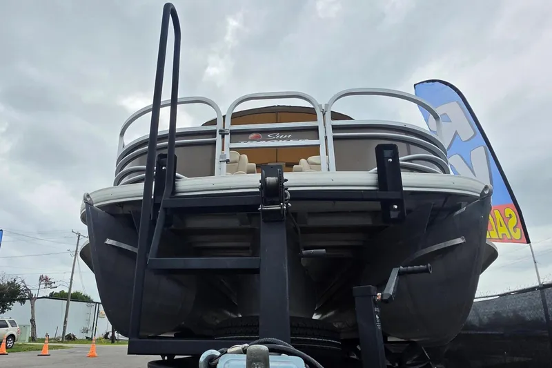 Slide: The Image of 2023 Sun Tracker Bass Buggy 18 DLX pontoon boat on trailer, overcast sky background. - 10