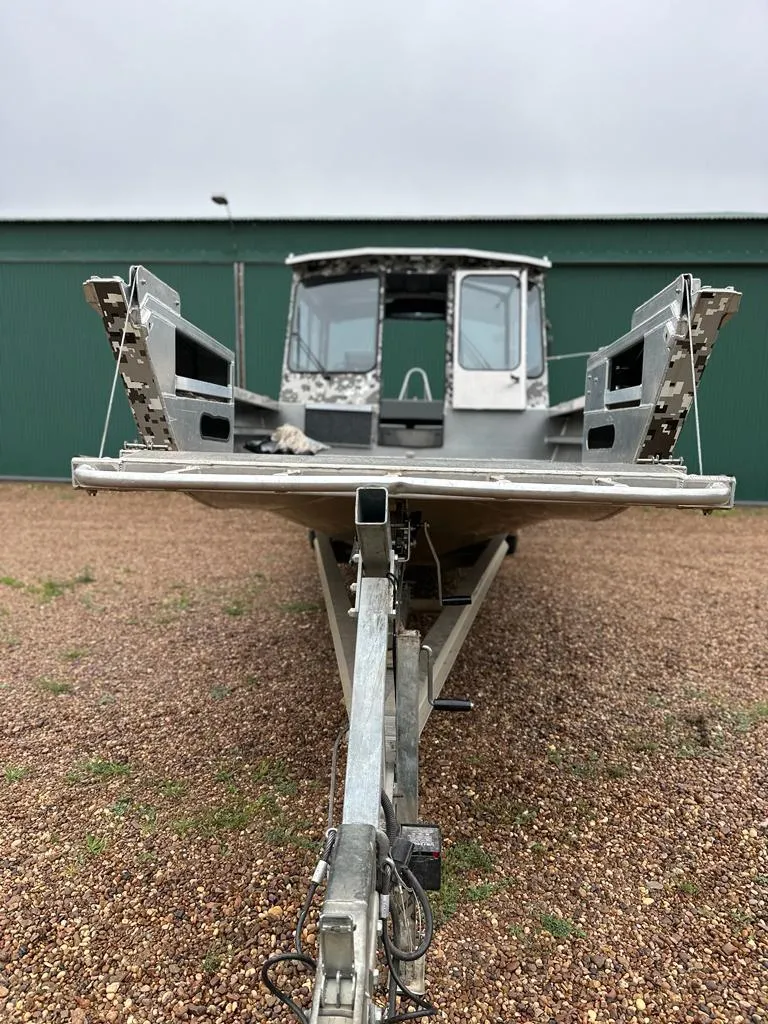 Slide: The Image of 2014 Wooldridge 31 boat on a trailer, front view, parked on gravel. - 3