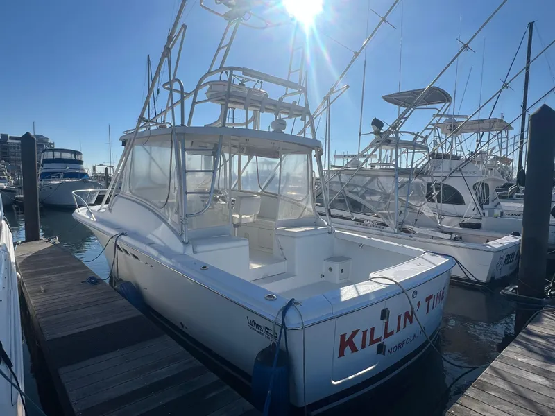Slide: The Image of 1995 Luhrs Tournament 290 Open boat docked at marina under bright sunlight. - 1