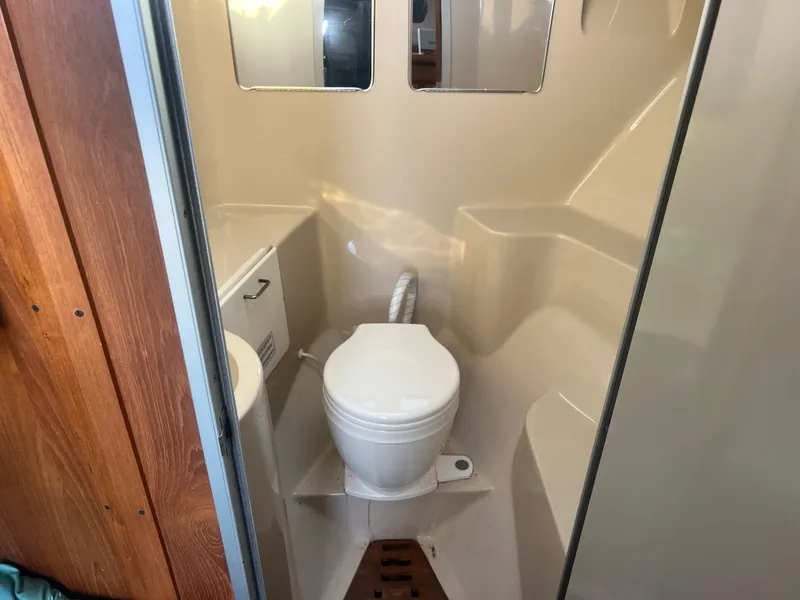 Slide: The Image of 1995 Luhrs Tournament 290 Open boat bathroom with toilet and wooden accents. - 22