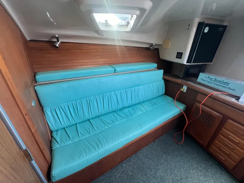 Slide: The Image of 1995 Luhrs Tournament 290 Open cabin interior with teal seating and wooden cabinetry. - 23