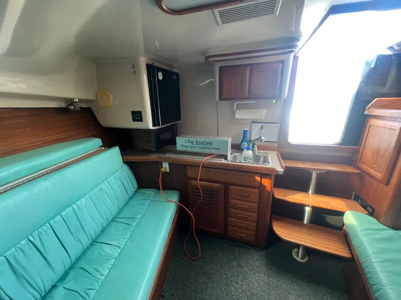 Slide: The Image of 1995 Luhrs Tournament 290 Open cabin interior with teal seating and kitchenette. - 24