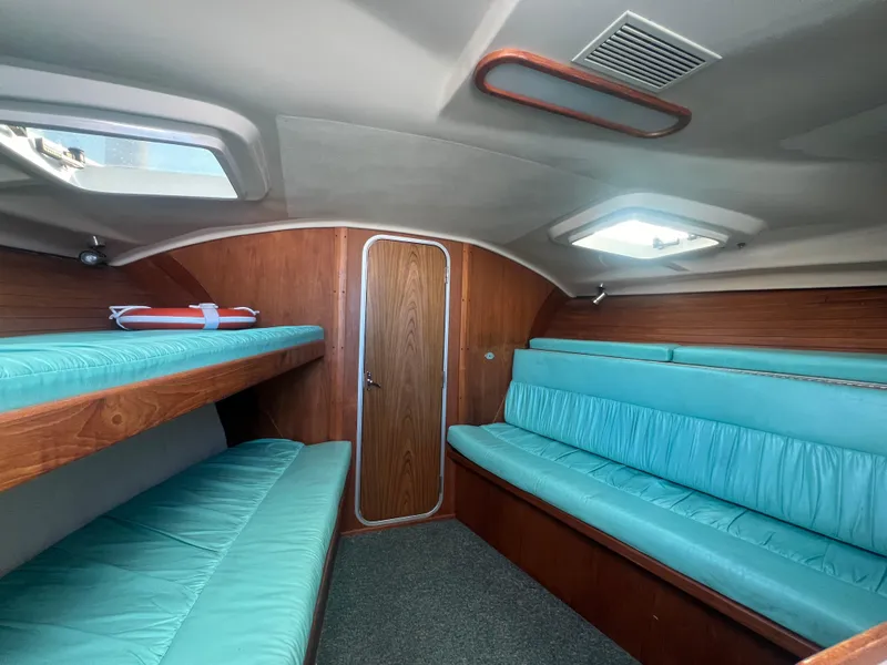 Slide: The Image of 1995 Luhrs Tournament 290 Open cabin interior with teal seating and wooden accents. - 26