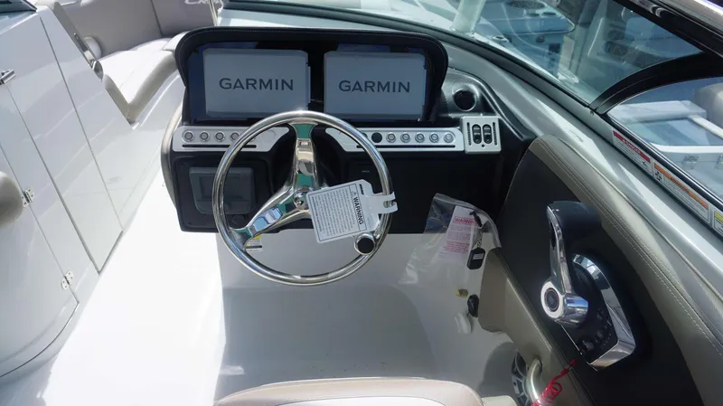 Slide: The Image of 2024 Crownline 240 DC boat dashboard with Garmin navigation displays and steering wheel. - 16