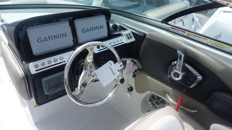 Slide: The Image of 2024 Crownline 240 DC boat dashboard with dual Garmin displays and steering wheel. - 17