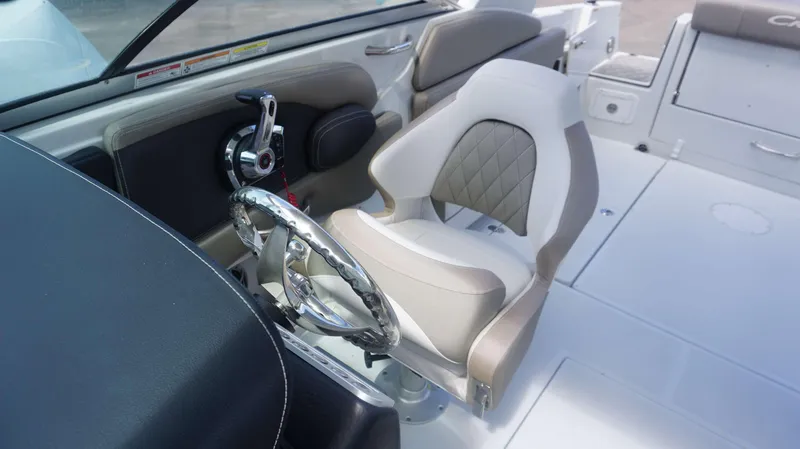 Slide: The Image of 2024 Crownline 240 DC boat interior with steering wheel and captain's chair. - 7