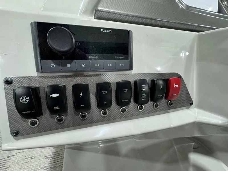 Slide: The Image of Control panel of 2024 Crest Classic LX 200 boat with switches and audio system. - 12