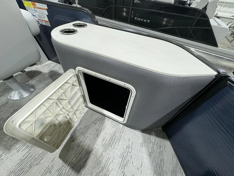 Slide: The Image of 2024 Crest Classic LX 200 boat interior with storage compartment and cup holders. - 13
