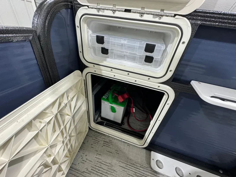 Slide: The Image of 2024 Crest Classic LX 200 storage compartment with battery and organizer box. - 15