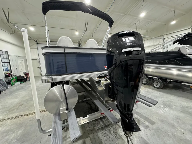 Slide: The Image of 2024 Crest Classic LX 200 pontoon boat with Mercury 115 outboard motor in a showroom. - 2