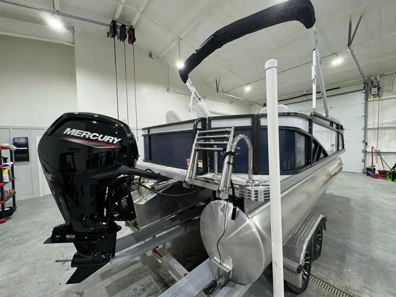Slide: The Image of 2024 Crest Classic LX 200 pontoon boat with Mercury outboard in a garage. - 3