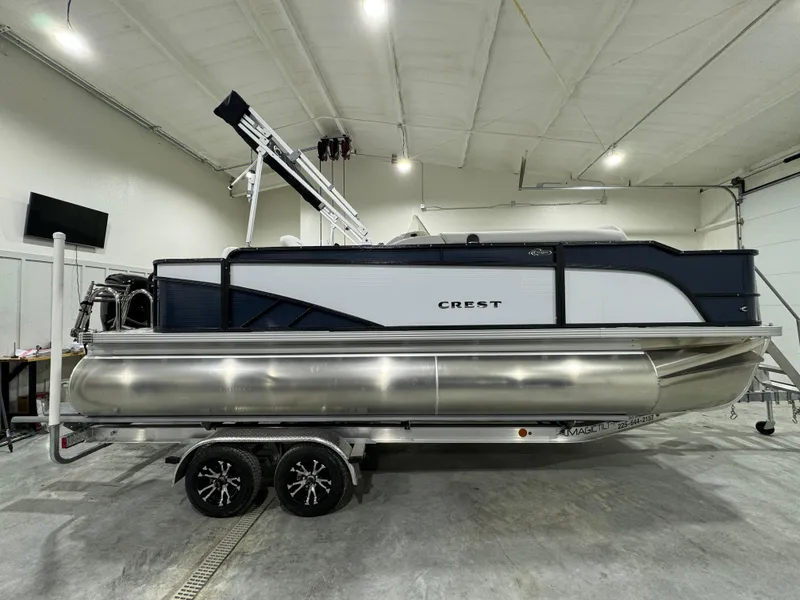 Slide: The Image of 2024 Crest Classic LX 200 pontoon boat in a showroom setting. - 4