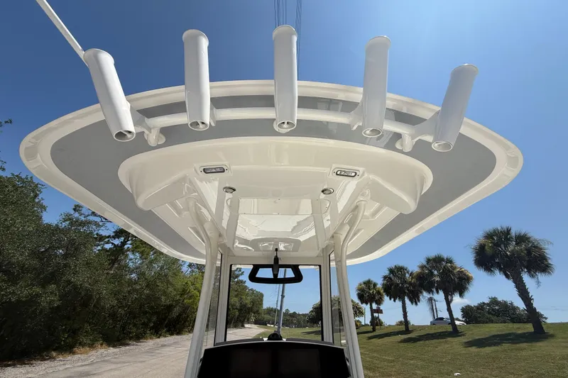 Slide: The Image of 2023 Regulator 26XO boat T-top with rod holders under clear blue sky. - 31
