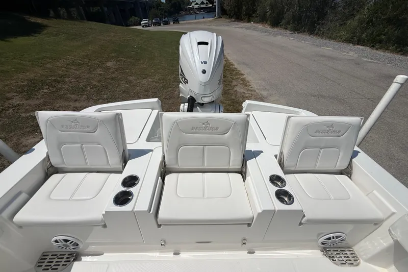 Slide: The Image of 2023 Regulator 26XO boat with three white cushioned seats and Yamaha V6 engine. - 27