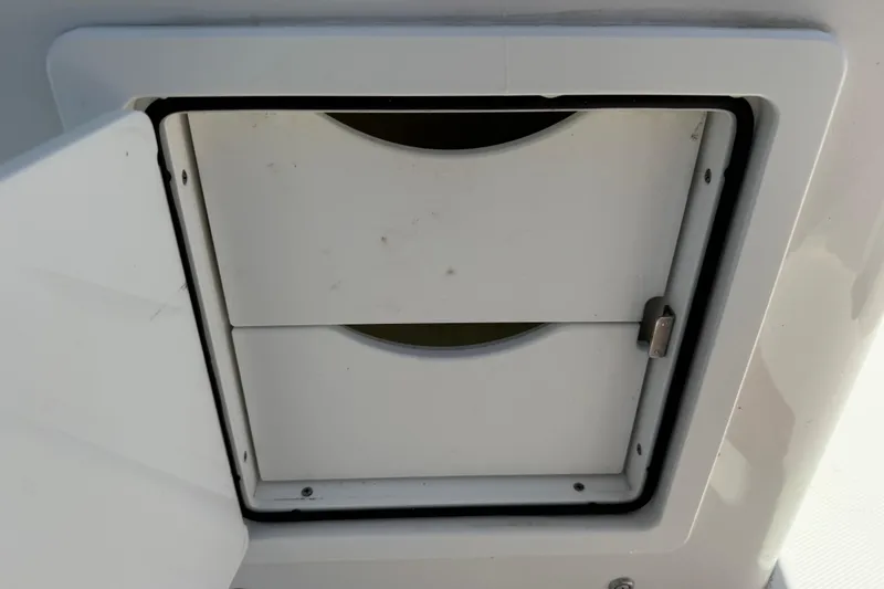 Slide: The Image of 2023 Regulator 26XO boat compartment with secure latch and white finish. - 51
