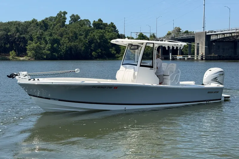Slide: The Image of 2023 Regulator 26XO boat on calm water near a bridge and trees. - 4