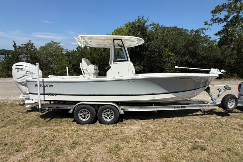 Slide: The Image of 2023 Regulator 26XO boat on trailer, featuring Yamaha engine, parked outdoors. - 6