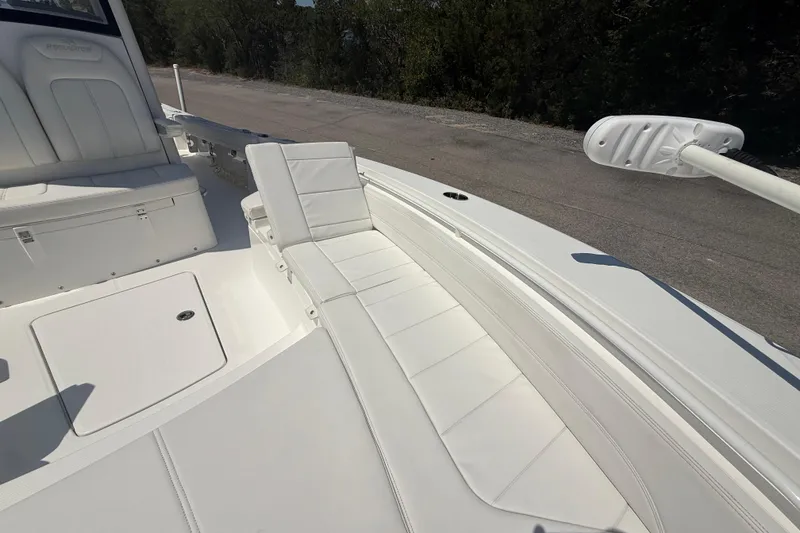 Slide: The Image of 2023 Regulator 26XO boat interior with white cushioned seating and storage compartments. - 36