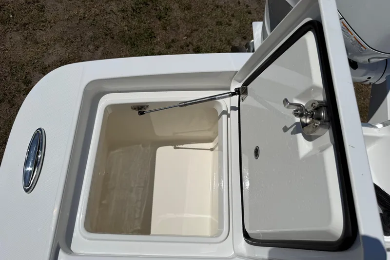 Slide: The Image of Open storage compartment on 2023 Regulator 26XO boat, showcasing interior design and latch mechanism. - 44