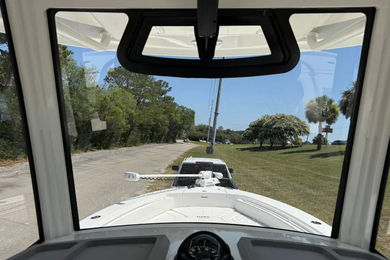 Slide: The Image of 2023 Regulator 26XO boat view from cockpit, parked on a scenic road. - 23