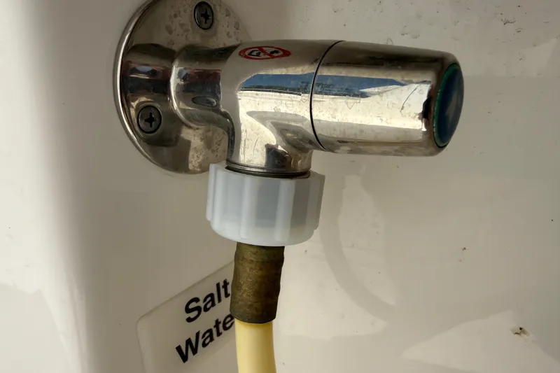 Slide: The Image of Saltwater faucet on 2023 Regulator 26XO boat, featuring a metal and plastic connection. - 48