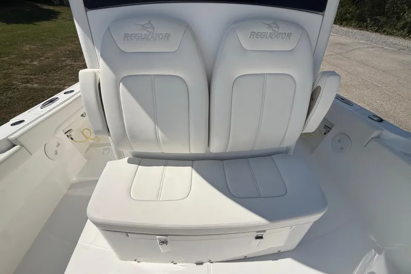 Slide: The Image of 2023 Regulator 26XO boat seating with white cushioned seats and storage compartment. - 32