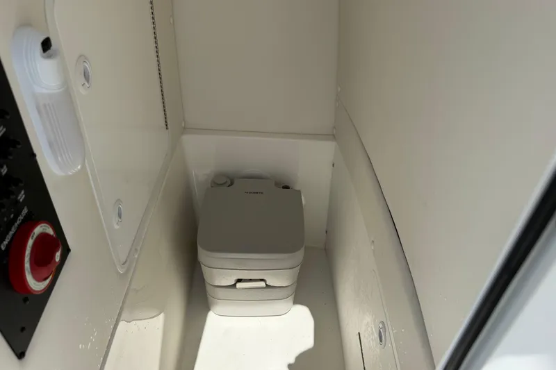 Slide: The Image of 2023 Regulator 26XO boat interior with compact marine toilet. - 39