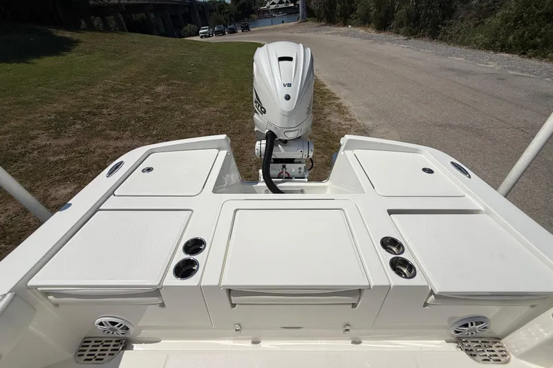 Slide: The Image of 2023 Regulator 26XO boat stern view with outboard motor and storage compartments. - 26