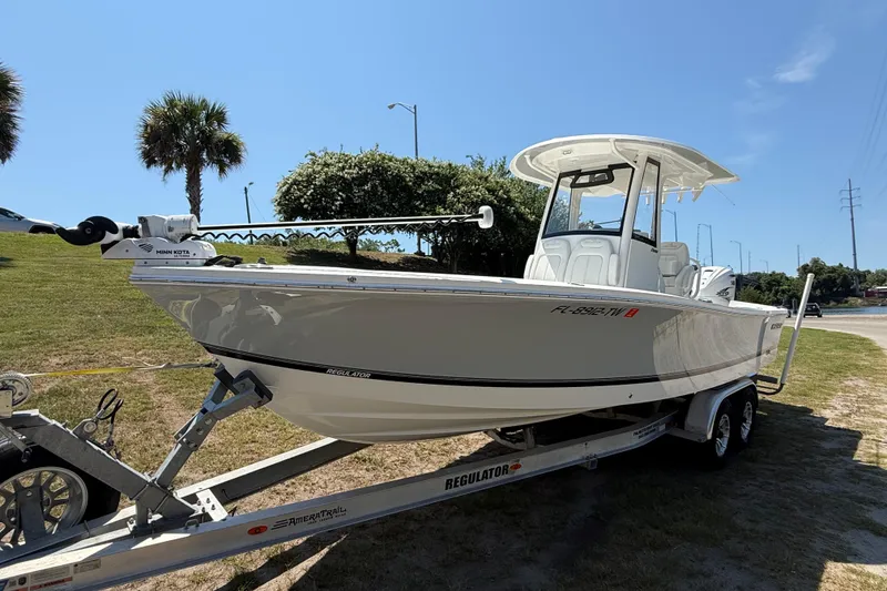 Slide: The Image of 2023 Regulator 26XO boat on trailer, parked outdoors under clear blue sky. - 10