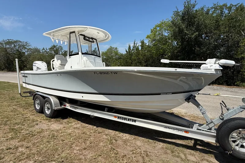Slide: The Image of 2023 Regulator 26XO boat on trailer, parked outdoors, side view. - 7
