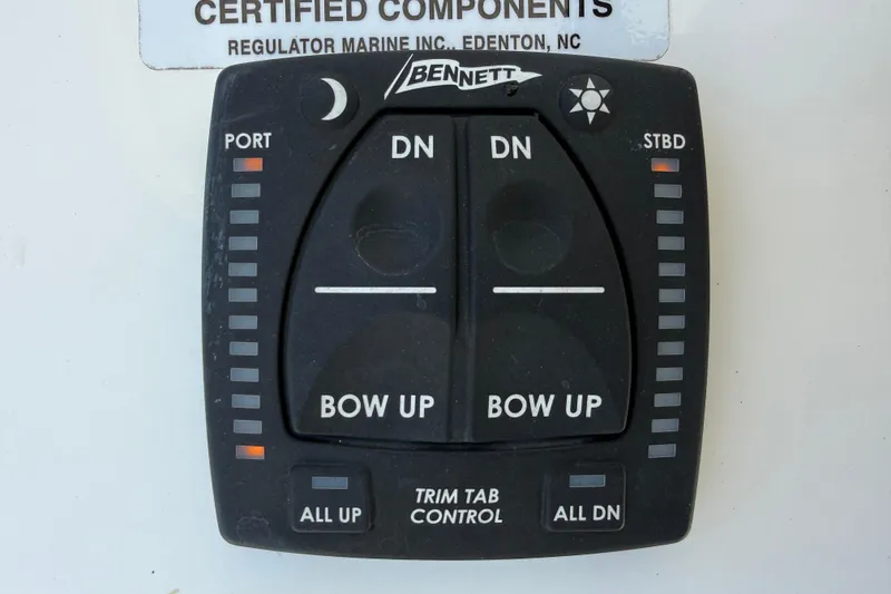 Slide: The Image of 2023 Regulator 26XO trim tab control panel with Bennett branding. - 21