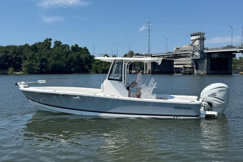Slide: The Image of 2023 Regulator 26XO boat on water near a bridge, featuring Yamaha engine. - 3
