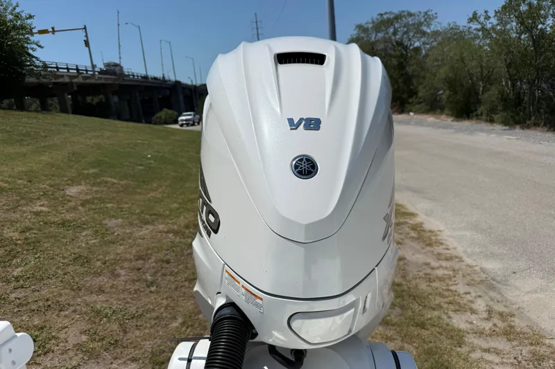 Slide: The Image of 2023 Regulator 26XO boat with Yamaha V8 engine, parked near a road. - 12