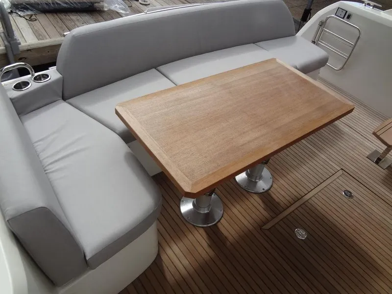 Slide: The Image of Prestige 420F 2024 boat interior with wooden table and cushioned seating. - 19
