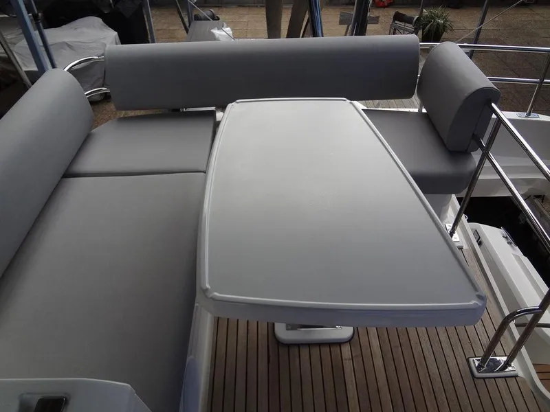 Slide: The Image of Prestige 420F 2024 boat with grey cushioned seating and table on deck. - 32