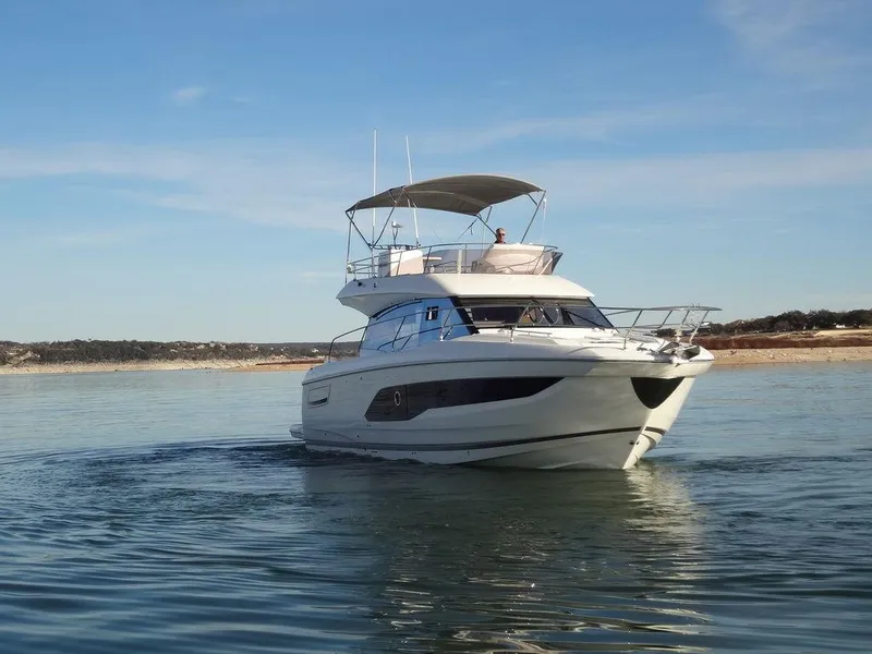 Slide: The Image of 2024 Prestige 420F yacht cruising on a calm lake under a clear sky. - 7