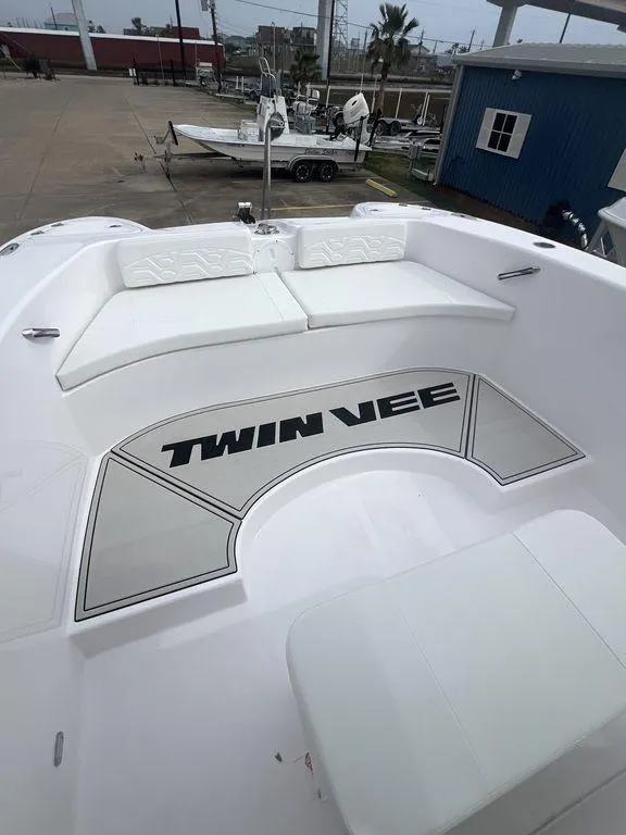 Slide: The Image of 2024 Twin Vee 280 STX boat deck with cushioned seating and logo. - 11