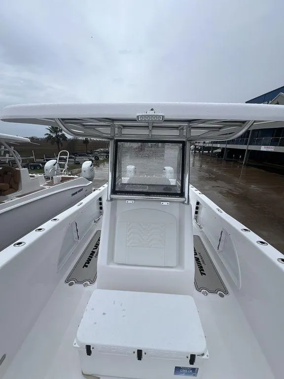 Slide: The Image of 2024 Twin Vee 280 STX boat with T-top and spacious deck in marina setting. - 16