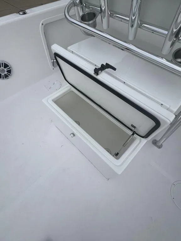 Slide: The Image of 2024 Twin Vee 280 STX boat storage compartment with open lid and stainless steel railing. - 19