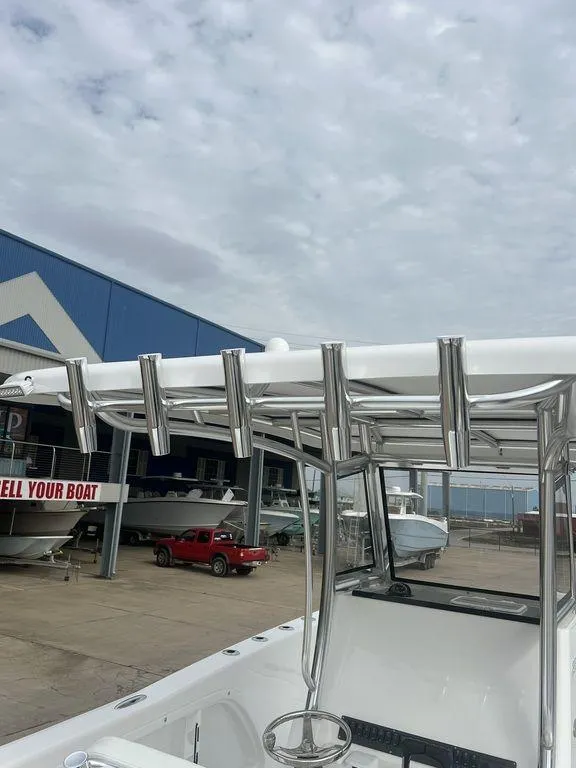 Slide: The Image of 2024 Twin Vee 280 STX boat with T-top and rod holders at a marina. - 27