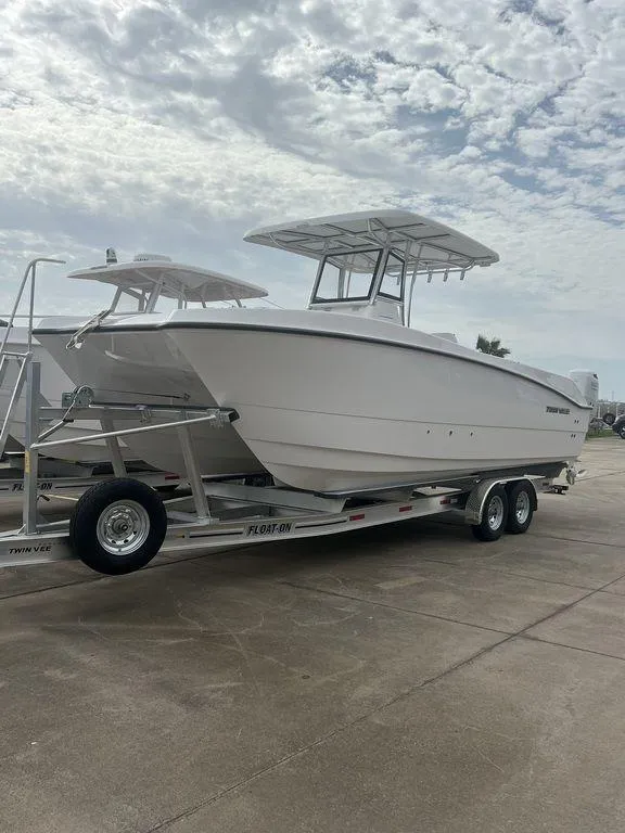 Slide: The Image of 2024 Twin Vee 280 STX boat on trailer under cloudy sky. - 3